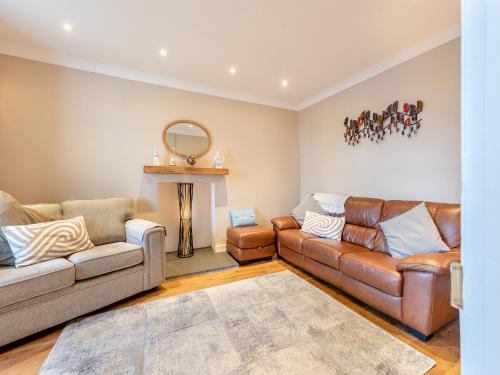 un salon avec deux canapés et une cheminée dans l'établissement Bettys Cottage, à New Quay