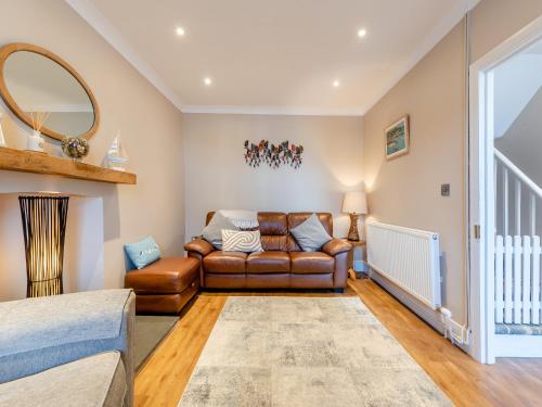 - un salon avec un canapé en cuir et un miroir dans l'établissement Bettys Cottage, à New Quay