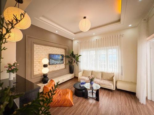 a living room with a couch and a table at De Brume Villa in Da Lat