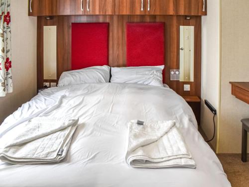 a white bed with two towels on top of it at The View in Whitstable