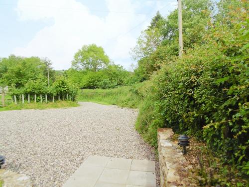 a gravel road next to a green hedge at Applebarrel Barn in Dunkeswell