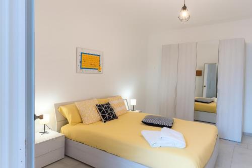 a bedroom with a yellow bed and a mirror at Casa cobalto vicinissima al centro by Turin House Collection in Turin