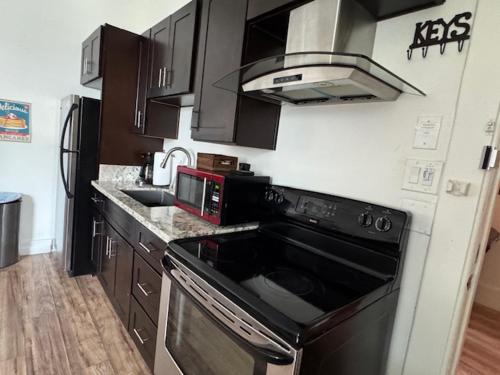 Il comprend une cuisine équipée d'une cuisinière noire et d'un four micro-ondes. dans l'établissement Walk everywhere heart Gaslamp, à San Diego