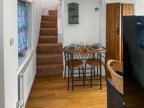 a small table in a room with a staircase at Ddwylig Bach - Uk48623 in St Asaph