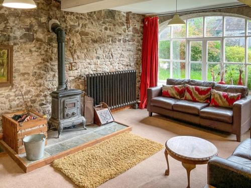 a living room with a couch and a wood stove at Brewhouse - Uk48743 in Llandybie