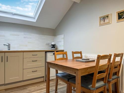 a kitchen with a table and chairs and a skylight at The Old Hayloft-Uk39431 in Dronfield