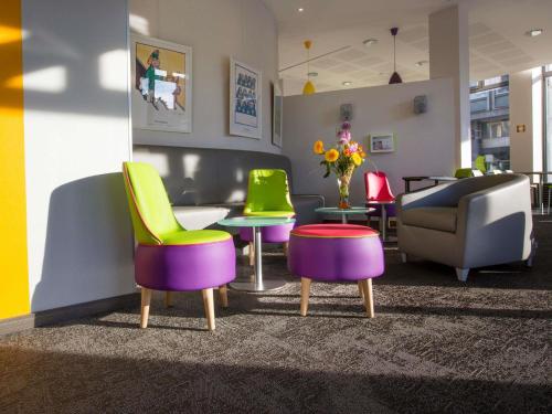 a lobby with colorful chairs and tables and a couch at ibis Styles Strasbourg Centre Petite France in Strasbourg