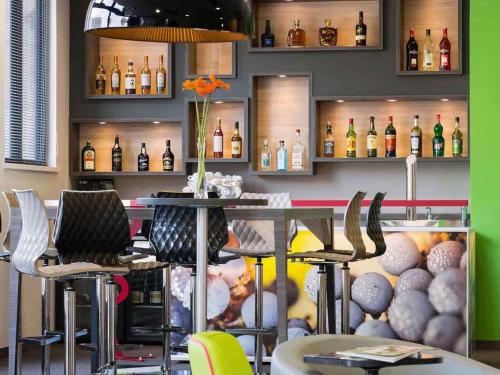 a restaurant with a bar with chairs and bottles at ibis Styles Strasbourg Centre Petite France in Strasbourg