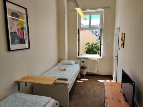 a room with two beds and a table and a window at Cozy Flat at Žižkov & Free Parking in Prague