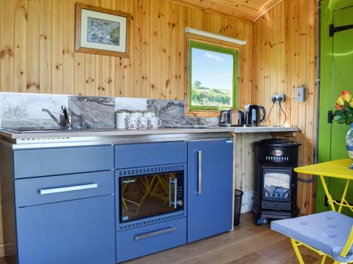 a kitchen with blue cabinets and a stove at Martha's Place in Bradley
