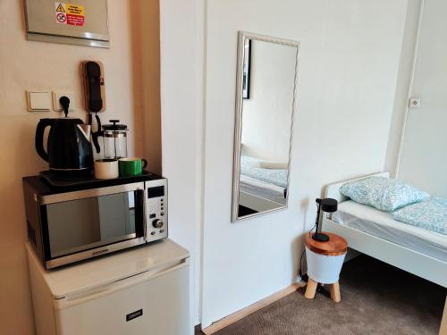 a room with a microwave on a dresser with a mirror at Cozy Flat at Žižkov & Free Parking in Prague
