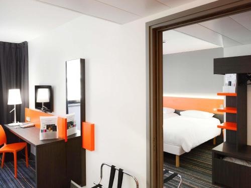 a bedroom with a bed and a desk and a mirror at ibis Styles Caen centre gare in Caen