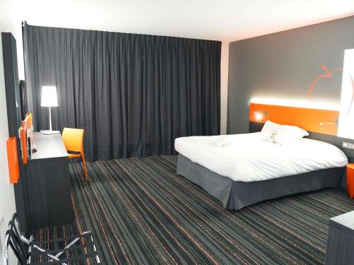 a hotel room with a bed and a television at ibis Styles Caen centre gare in Caen