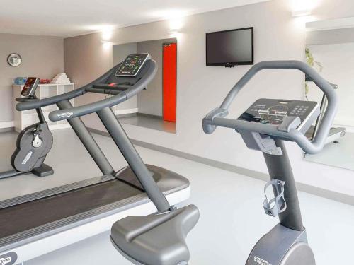 a gym with two tread machines and a television at ibis Styles Caen centre gare in Caen