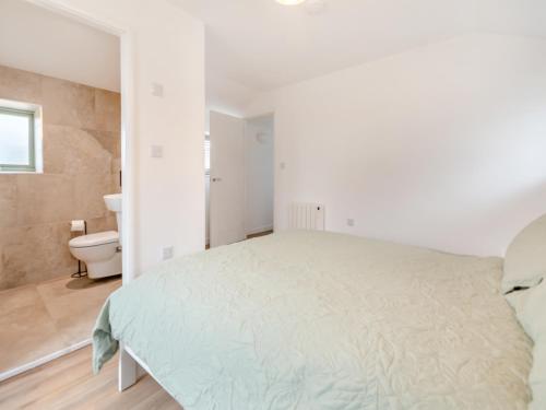 a white bedroom with a bed and a toilet at Wheel House - Uk41247 in Hawsker