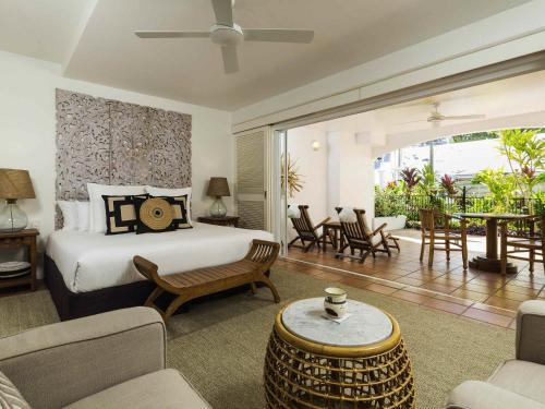 a bedroom with a bed and a living room at The Reef House Adults Retreat - Enjoy 28 Complimentary Inclusions in Palm Cove