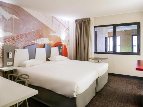 a hotel room with a large bed and a window at ibis Styles Poitiers Centre in Poitiers