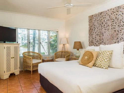 a bedroom with a large white bed and a window at The Reef House Adults Retreat - Enjoy 28 Complimentary Inclusions in Palm Cove