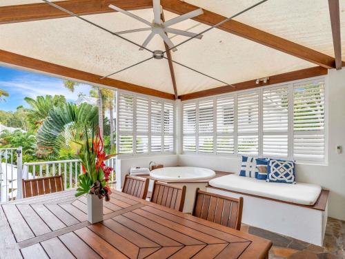 a room with a table and chairs on a deck at The Reef House Adults Retreat - Enjoy 28 Complimentary Inclusions in Palm Cove