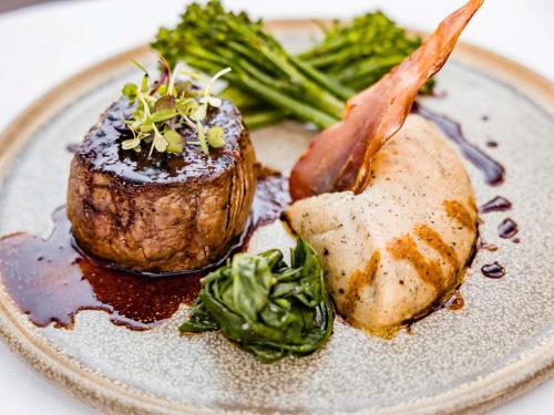 a plate of food with a piece of meat and vegetables at The Reef House Adults Retreat - Enjoy 28 Complimentary Inclusions in Palm Cove