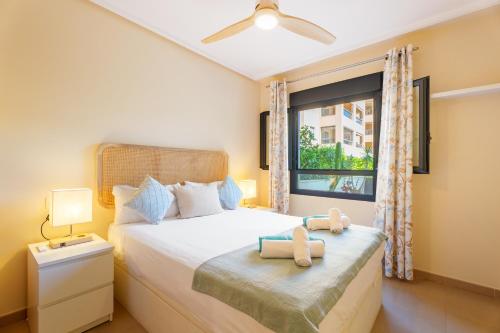 a bedroom with a bed with two teddy bears on it at Hogar Brisa de las Marinas acogedor apartamento con amplia terraza y acceso directo a las piscinas-Comfortable apartment with spacious terrace and direct pool access in Denia