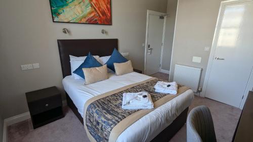 a bedroom with a bed with towels on it at Alexandra Hotel in Eastbourne
