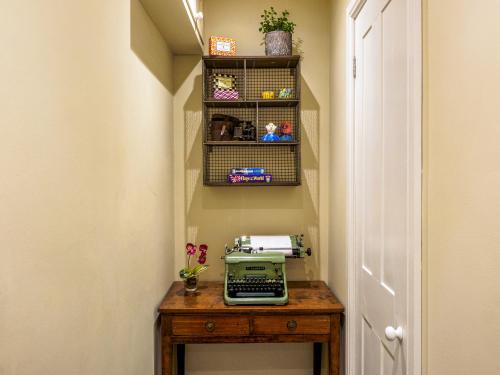 a hallway with a sewing machine on a wooden table at Hollyhock in Tavistock