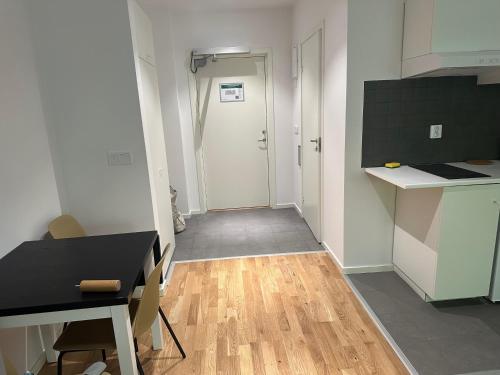 a kitchen with a table and a door to a hallway at Big Studio Apartment in Sollentuna Stockholm in Nora