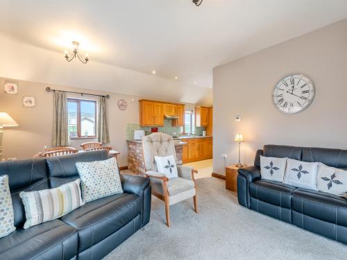 - un salon avec des canapés et une horloge murale dans l'établissement Ash Cottage - Uk45581, à Maltby le Marsh