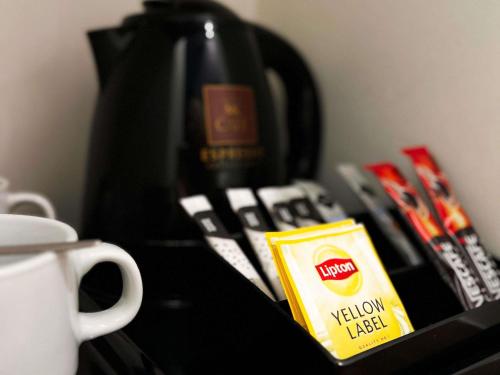 a black table with a coffee pot and a box of tea at ibis Styles Wałbrzych in Wałbrzych