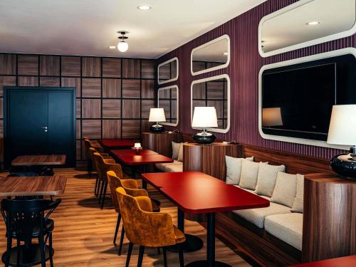 a restaurant with red walls and tables and a couch at ibis Styles Wałbrzych in Wałbrzych