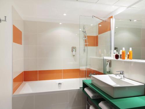 a bathroom with a tub and a sink and a shower at ibis Styles Montpellier Centre Comedie in Montpellier