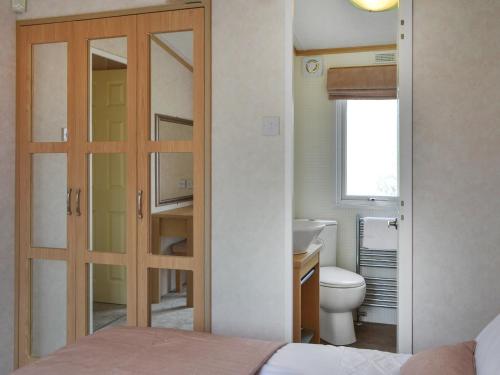 a bathroom with a door leading to a toilet at Number 45 in Patrington