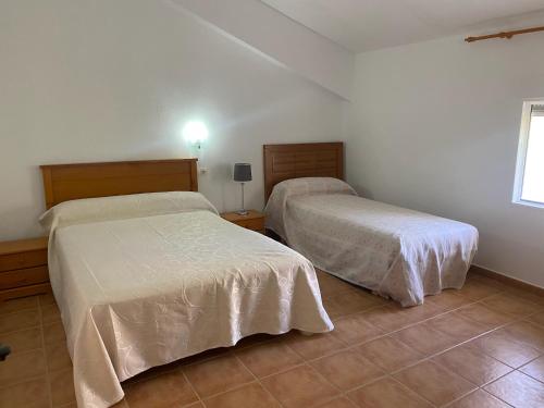 a bedroom with two beds and a window at Casa azul in Nerpio