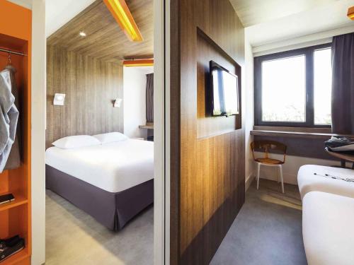 two views of a hotel room with a bed and a bathroom at ibis Styles Niort Poitou Charentes in Vouillé