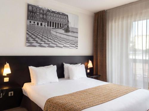 Ένα ή περισσότερα κρεβάτια σε δωμάτιο στο Aparthotel Adagio Nice Promenade des Anglais