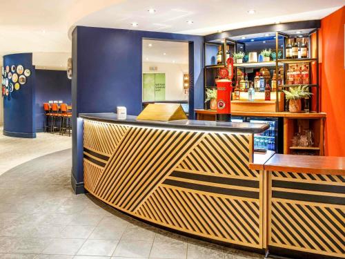 a bar in a restaurant with blue walls at ibis Styles Birmingham Centre in Birmingham