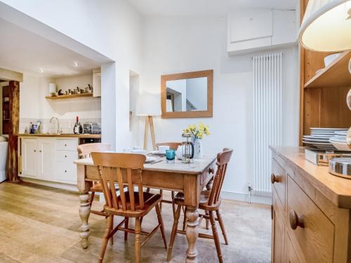 una cucina e una sala da pranzo con tavolo e sedie in legno di September Cottage a Wenhaston