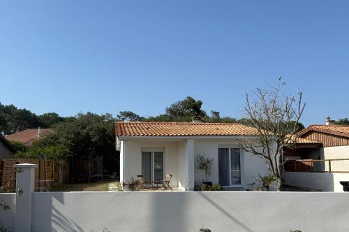 a white fence in front of a house at Maison de La Vague Lacanau Ocean in Lacanau