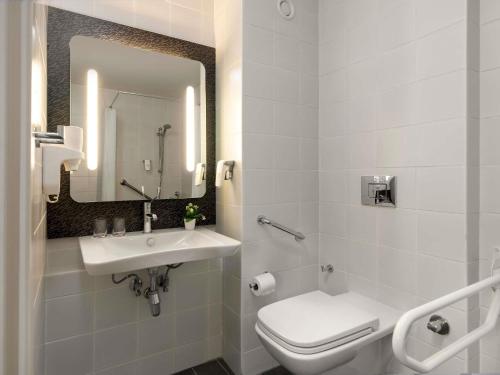 a bathroom with a sink and a toilet and a mirror at ibis Ankara Airport Hotel in Ankara