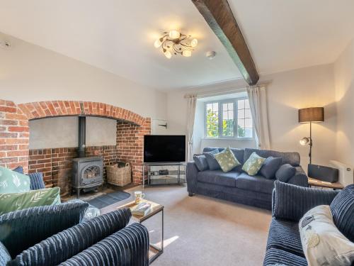 a living room with a couch and a fireplace at The Farmhouse, Ley Farm in Yarcombe