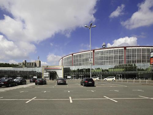 a parking lot with cars parked in front of a building at Mercure Hotel Dortmund Messe in Dortmund