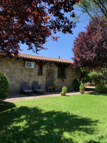 a stone house with two chairs in a yard at Naturaleza, Confort y Magnificas vistas a Sierra de Gata TR-CC-00490 in Gata