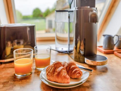 un tavolo con un piatto di croissant e bicchieri di succo d'arancia di The Hay Loft - Uk46737 a Shapwick