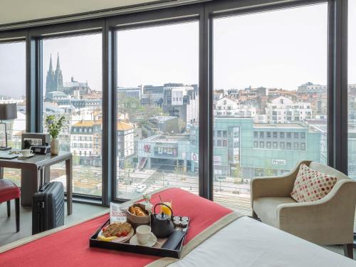 a hotel room with a tray of food on a bed at Mercure Clermont Ferrand centre Jaude in Clermont-Ferrand