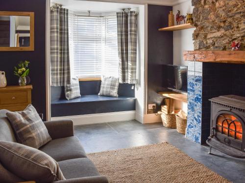 a living room with a couch and a fireplace at White Horses - Uk42776 in Newborough