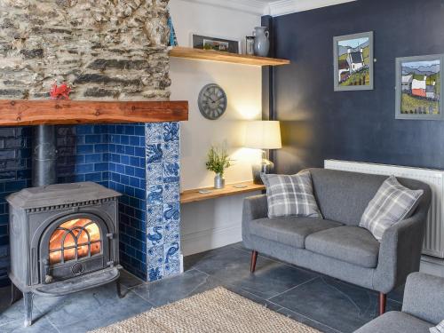 a living room with a couch and a fireplace at White Horses - Uk42776 in Newborough