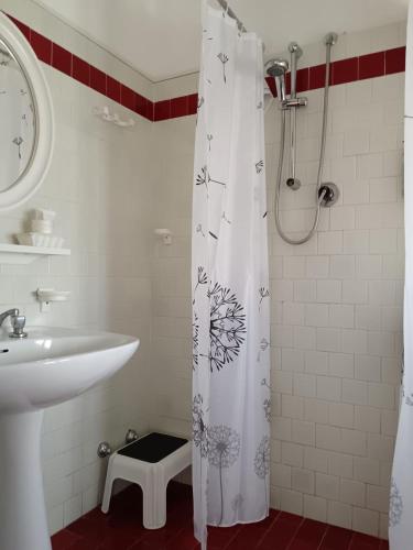 a bathroom with a shower curtain and a sink at Hotel Nazionale in Lido di Jesolo