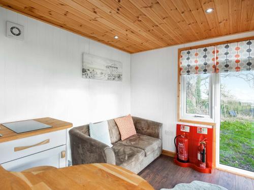 un piccolo soggiorno con divano e finestra di School Lodge a Burwarton