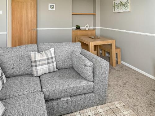 a living room with a couch and a table at Sunrise Cottage - Uk35813 in Llanddulas